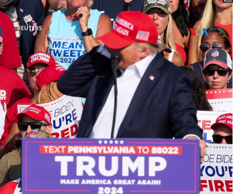 El candidato presidencial republicano y expresidente Donald Trump recibe ayuda para salir del escenario en un evento de campaña en Butler, Pensilvania, el 13 de julio de 2024.