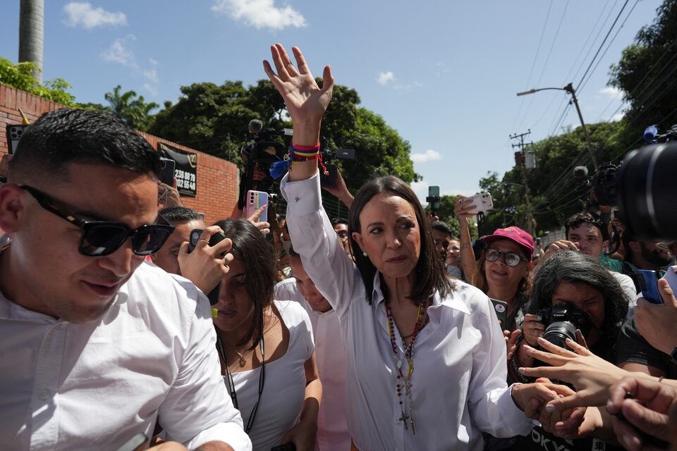 Venezuelan opposition leader Maria Corina Machado waves as she walks outside a polling station during the country's presidential election, in Caracas, Venezuela July 28, 2024. REUTERS/Alexandre Meneghini